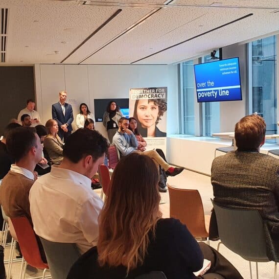 A conference room with full with participants sitting down to listen to Social Platform's Secretary General Laura de Bonfils give a welcome speech