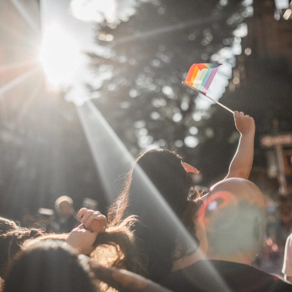 Crowd of people, young girl waving pride flag