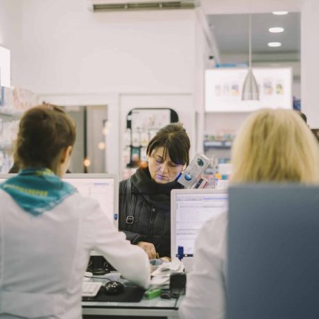 Chemist serving customer in shop